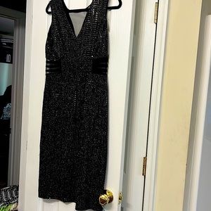 Black sequin dress with cutout sides with mesh. Mid-length fall at/below knee